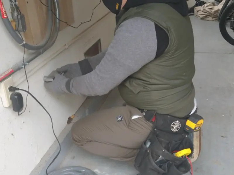 Electrician performing outlet wiring in a Livonia garage